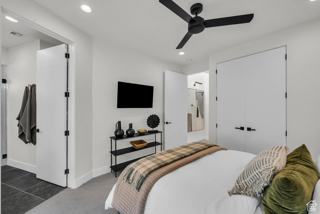 Bedroom with connected bathroom, a closet, ceiling fan, and dark colored carpet