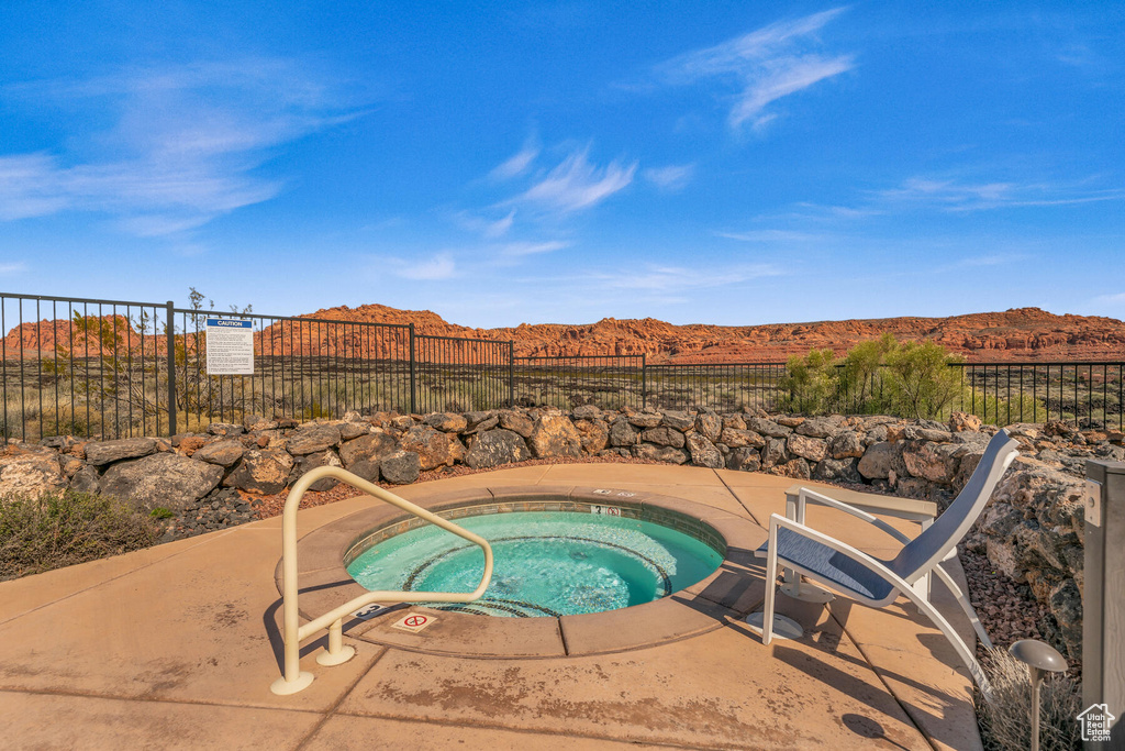 View of swimming pool with a community hot tub, a patio, and a mountain view