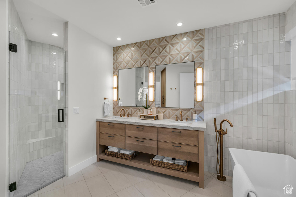 Bathroom with tile walls, double vanity, tasteful backsplash, and tile flooring