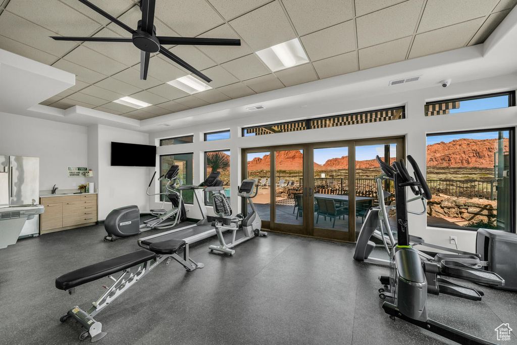 Gym featuring ceiling fan, a mountain view, a raised ceiling, a drop ceiling, and french doors