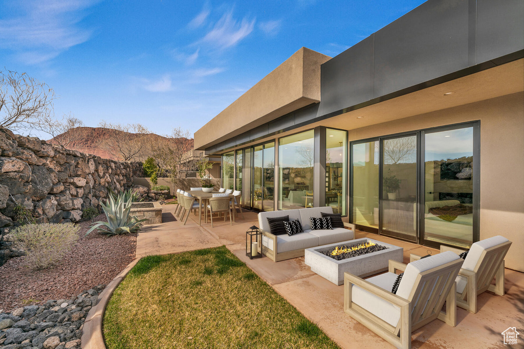View of yard with an outdoor living space with a fire pit, a mountain view, and a patio area