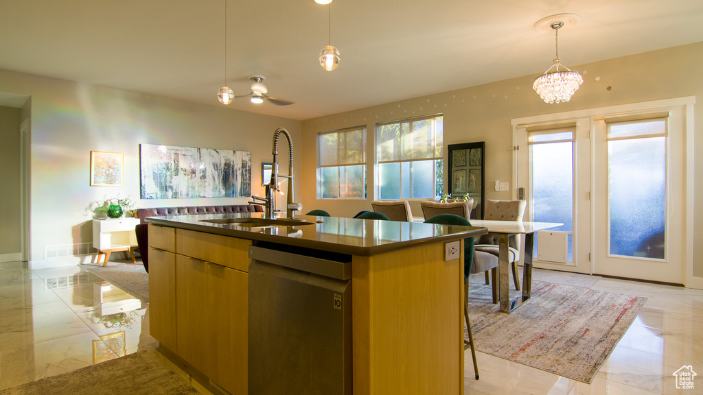 Kitchen with a kitchen island with sink, ceiling fan with notable chandelier, pendant lighting, light tile floors, and stainless steel dishwasher
