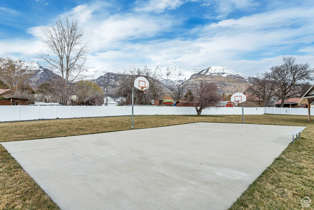 View of basketball court with a yard and a mountain view