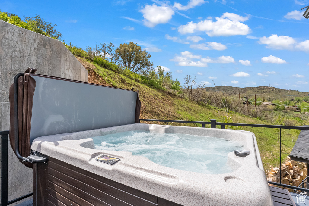 View of terrace featuring a hot tub and a mountain view