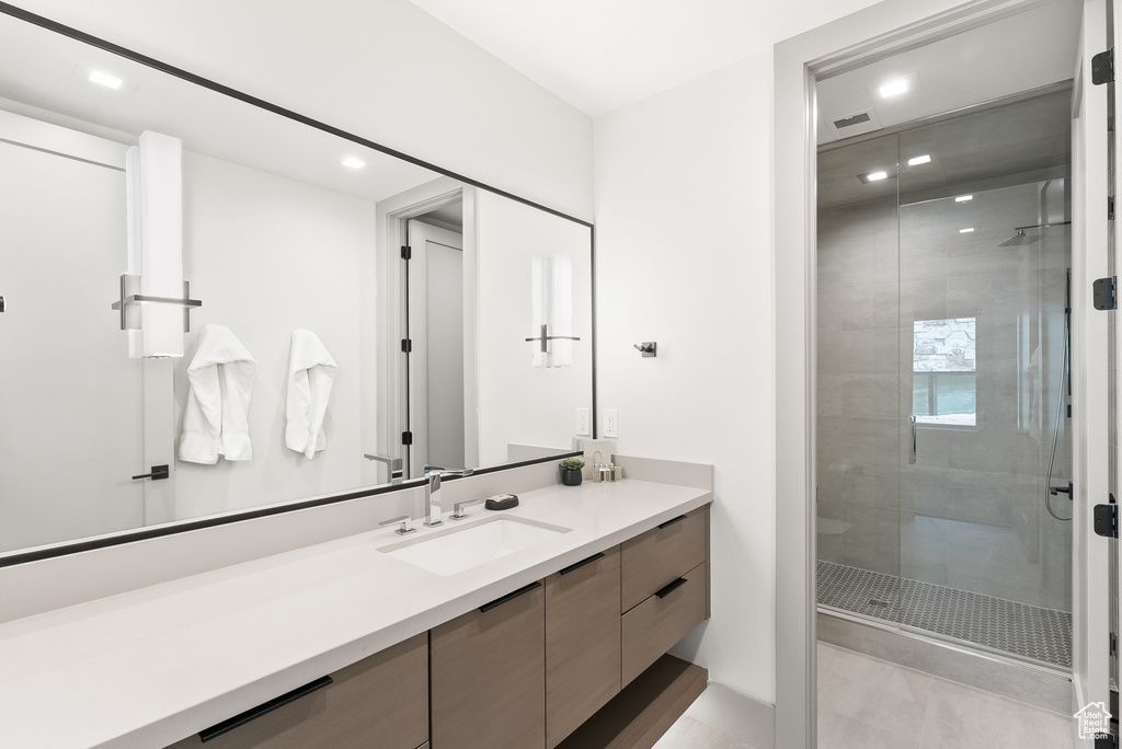 Bathroom featuring walk in shower, tile flooring, and oversized vanity