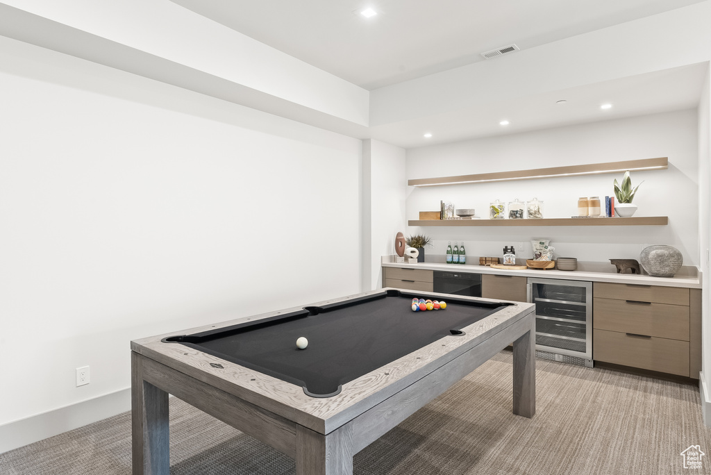 Rec room with indoor bar, light colored carpet, beverage cooler, and billiards