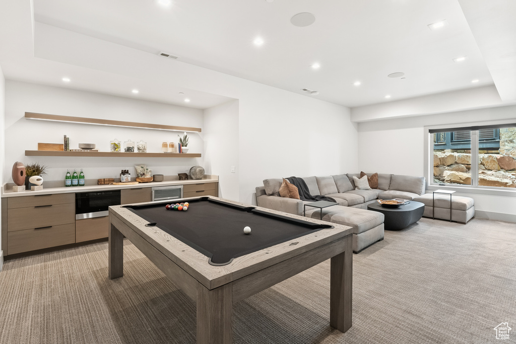 Playroom featuring light colored carpet, billiards, and bar area