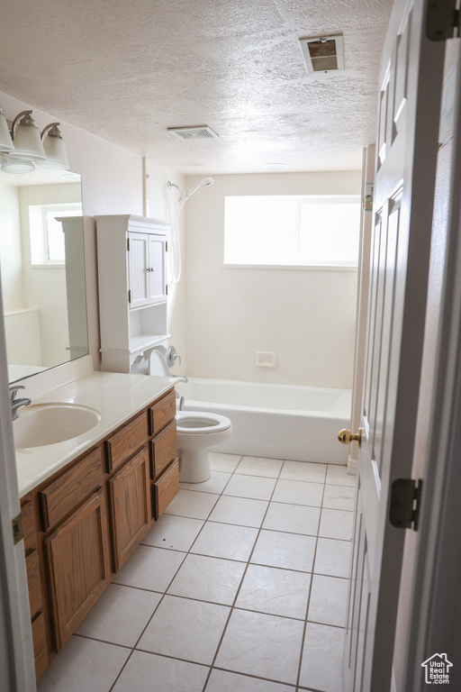 Full bathroom featuring a textured ceiling, tile floors, vanity,  shower combination, and toilet