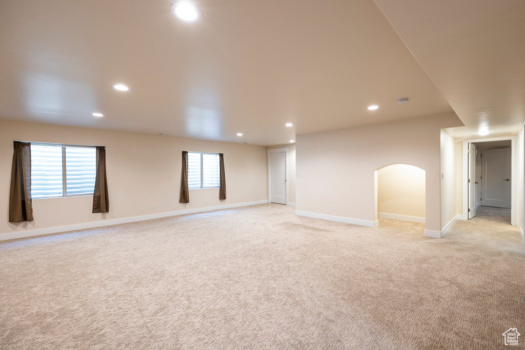Empty room featuring plenty of natural light and light colored carpet