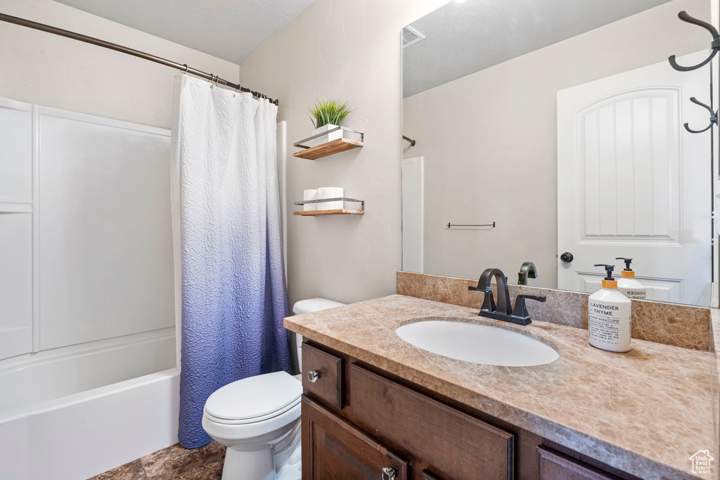 Full bathroom with oversized vanity, tile floors, toilet, and shower / tub combo with curtain