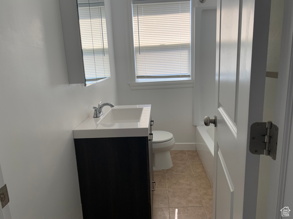 Full bathroom with tile flooring, shower / washtub combination, toilet, and vanity