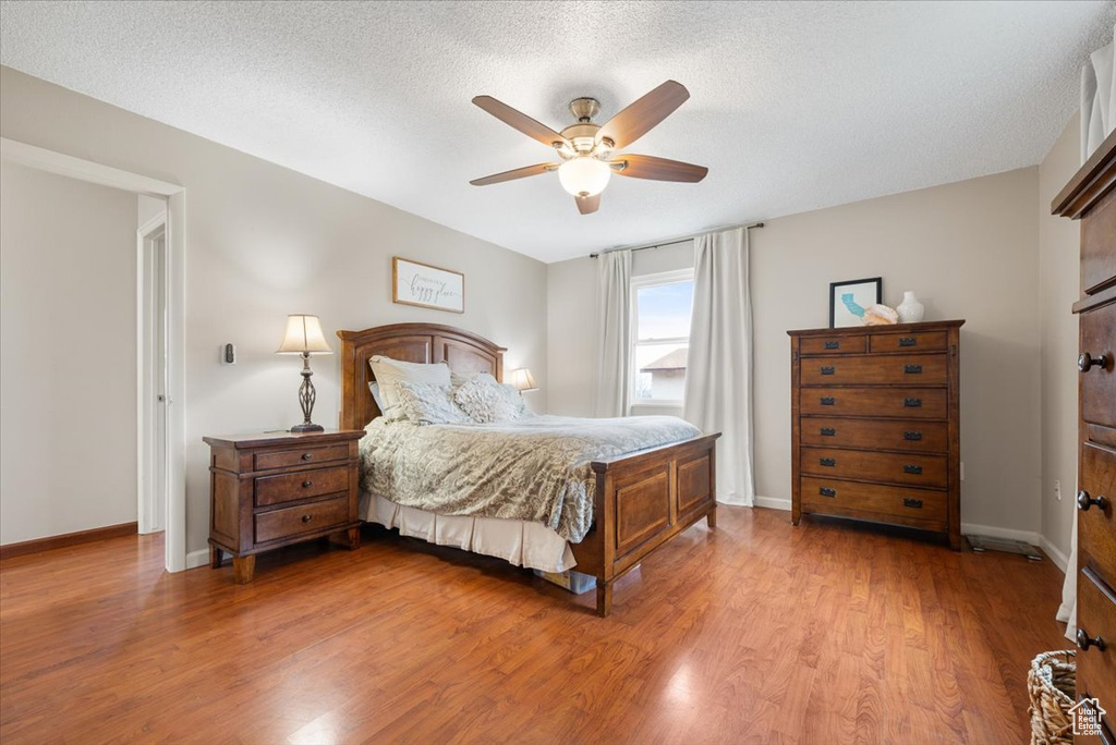 Bedroom featuring hardwood / wood-style flooring, a textured ceiling, and ceiling fan