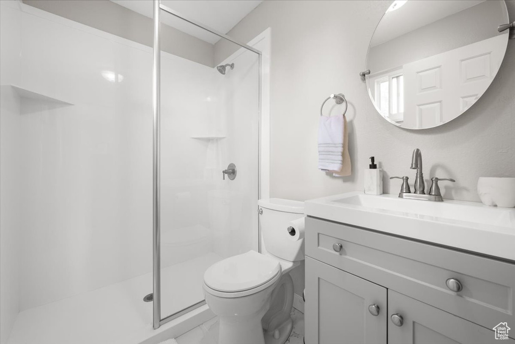 Bathroom featuring vanity, toilet, and an enclosed shower