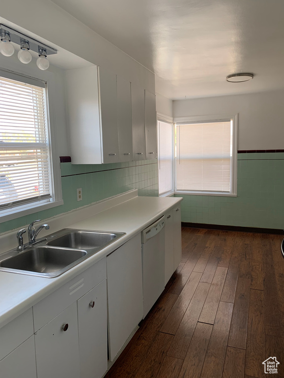 Kitchen with white cabinetry, sink, dark hardwood / wood-style flooring, dishwasher, and backsplash