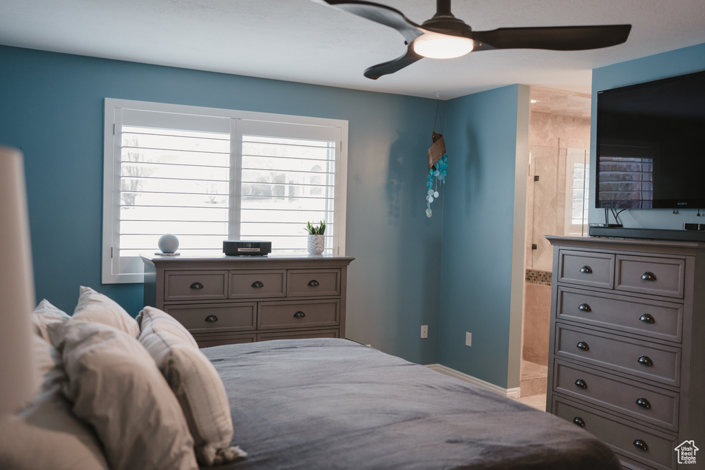Bedroom featuring multiple windows, ensuite bath, and ceiling fan