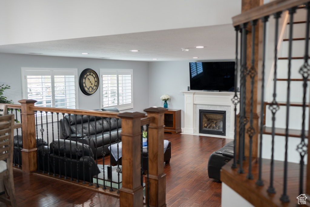 Living room with dark hardwood / wood-style flooring and a premium fireplace