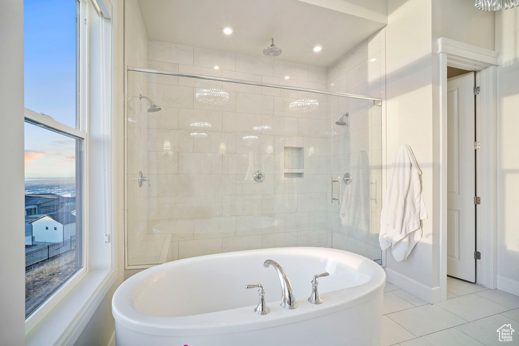 Bathroom with a wealth of natural light, independent shower and bath, and tile floors