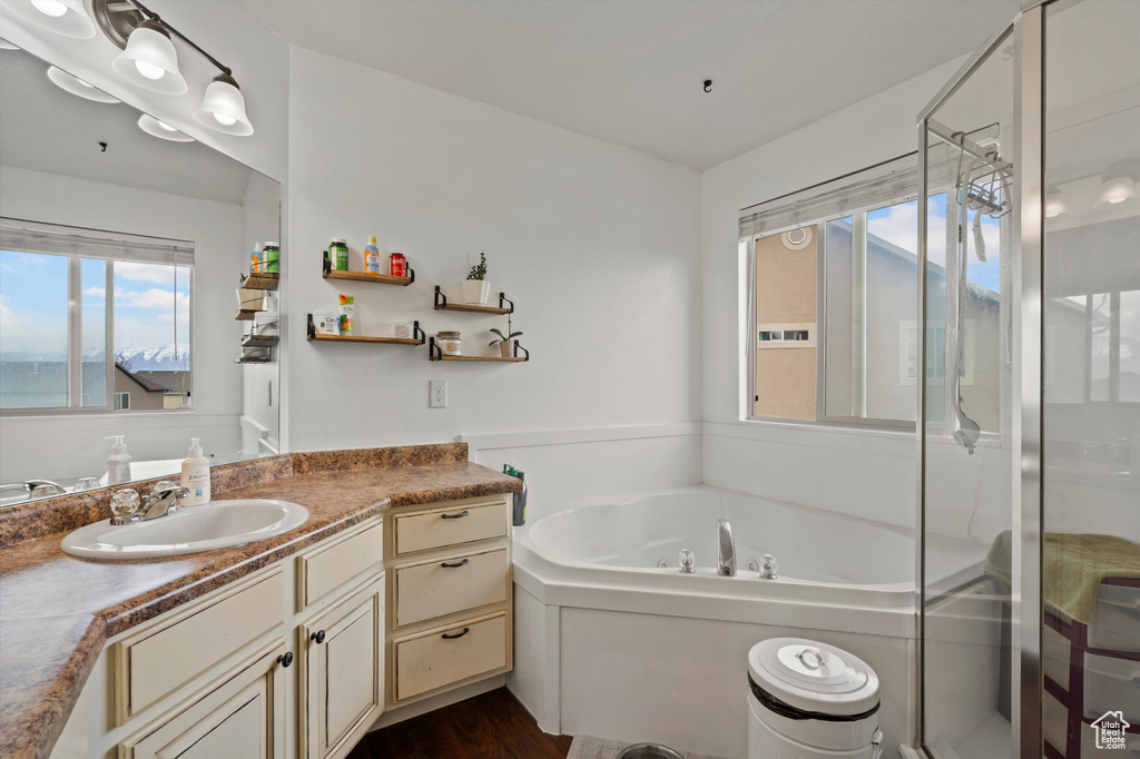 Bathroom featuring shower with separate bathtub, hardwood / wood-style flooring, and vanity