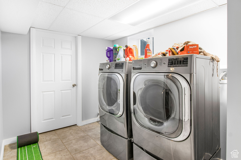 Laundry area with light tile floors and washing machine and dryer