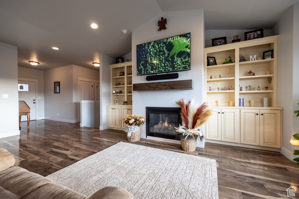 Living room featuring lofted ceiling and dark hardwood / wood-style floors