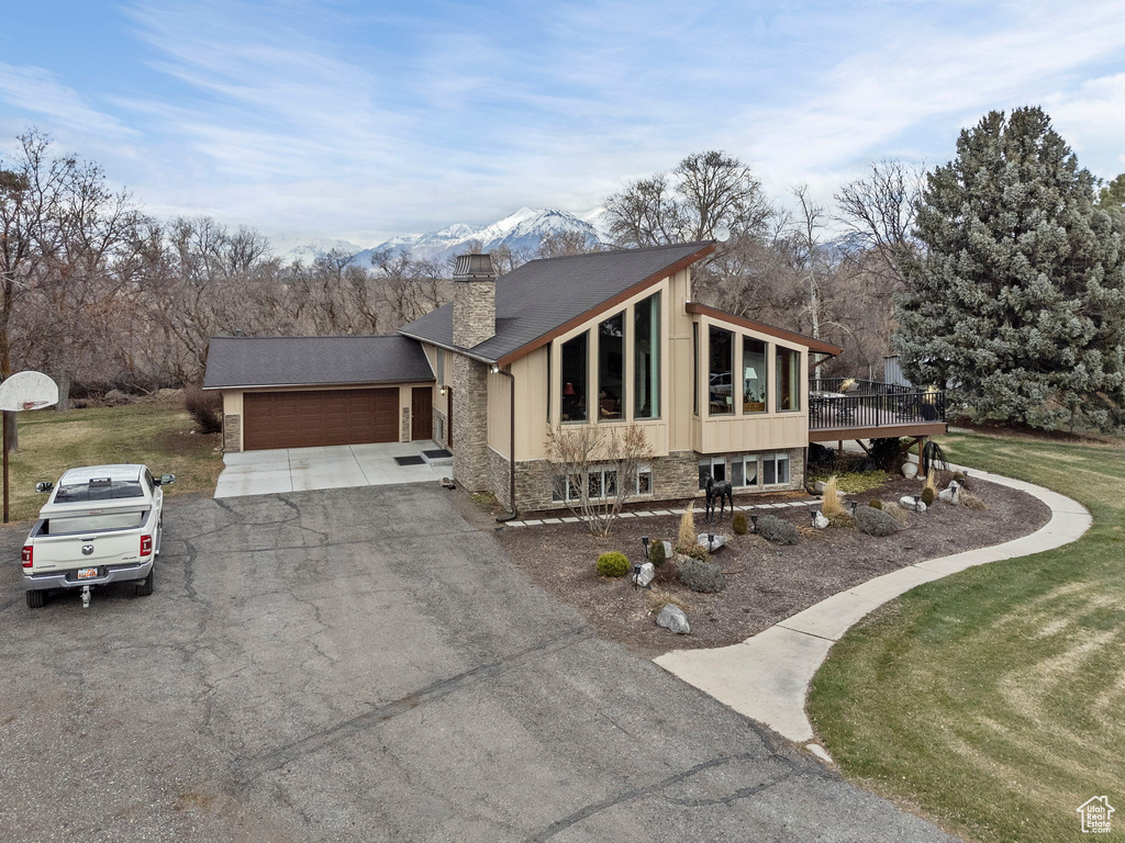 View of front of property with a mountain view, a garage, and a front yard