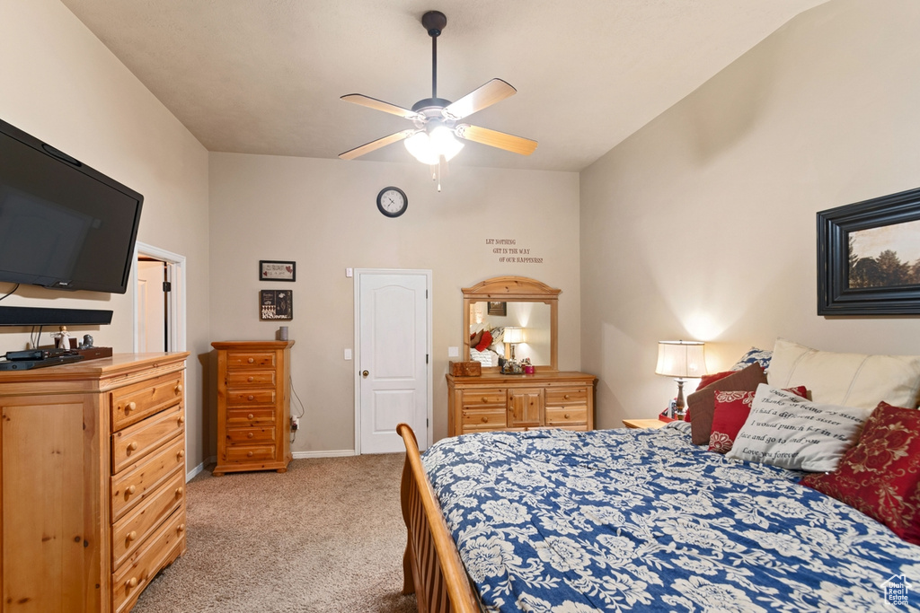 Bedroom with lofted ceiling, light carpet, and ceiling fan