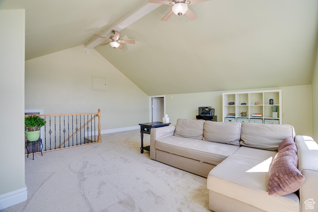 Living room with lofted ceiling with beams, light colored carpet, and ceiling fan