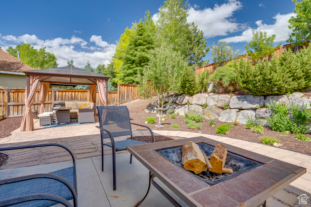 View of patio / terrace featuring an outdoor living space with a fire pit and a gazebo