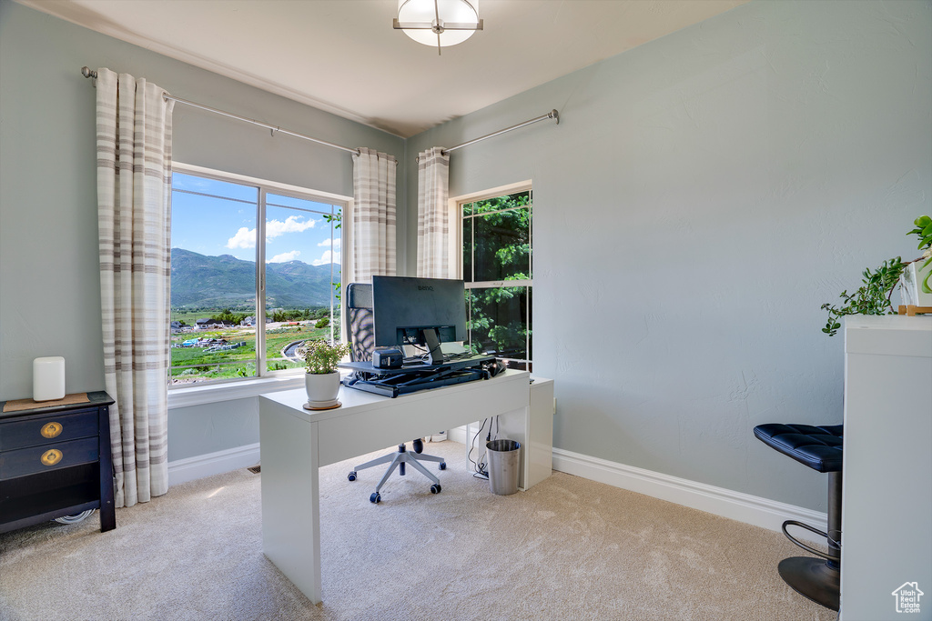 Carpeted home office with a healthy amount of sunlight and a mountain view