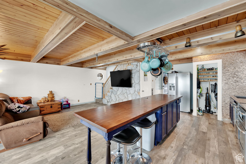 Kitchen with beamed ceiling, stainless steel fridge, wood ceiling, light hardwood / wood-style floors, and blue cabinets