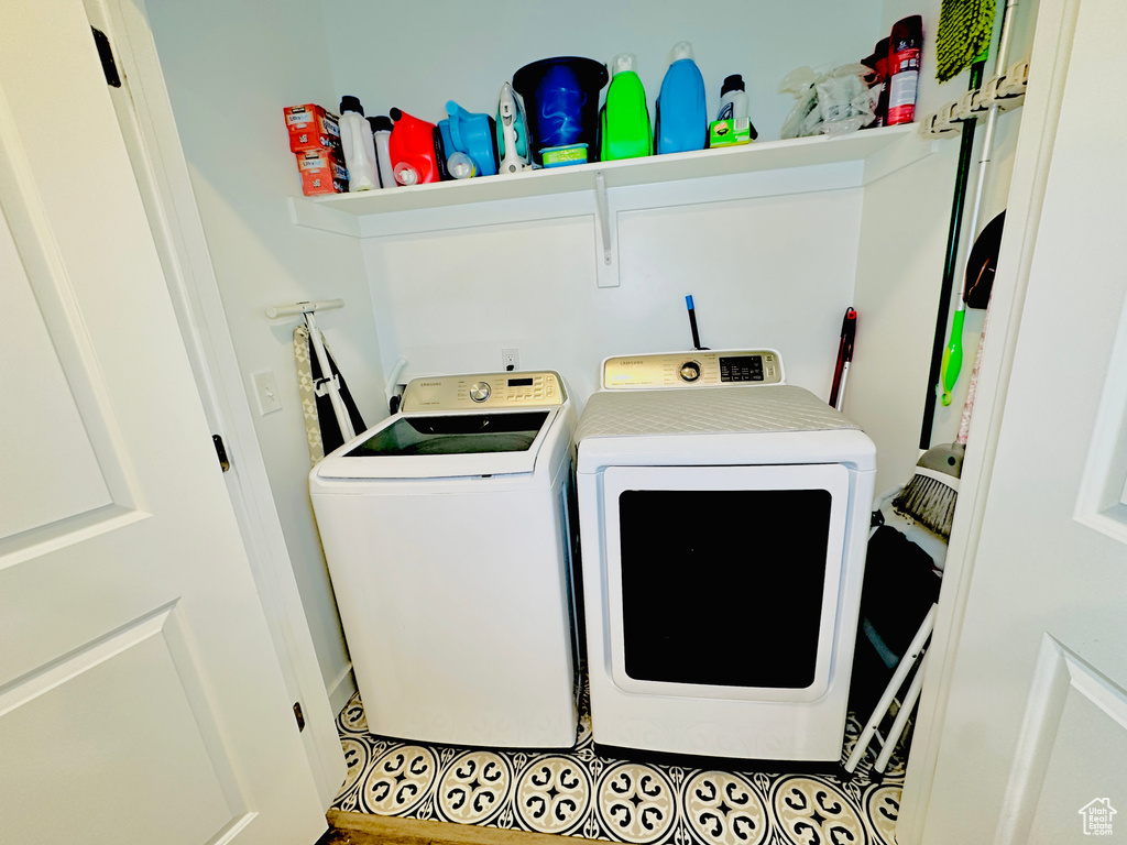 Laundry room with separate washer and dryer and light tile flooring