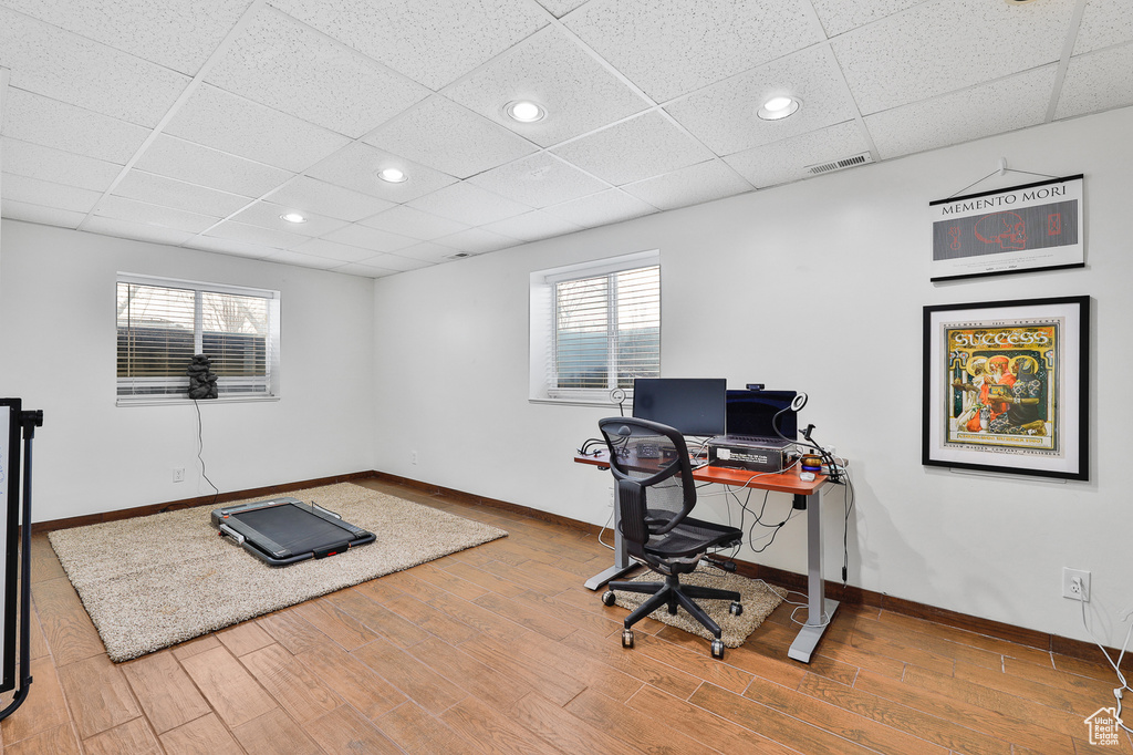 Office area featuring light hardwood / wood-style flooring and a paneled ceiling