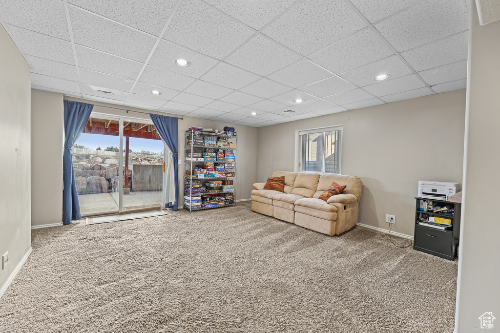 Living room featuring a drop ceiling and light colored carpet