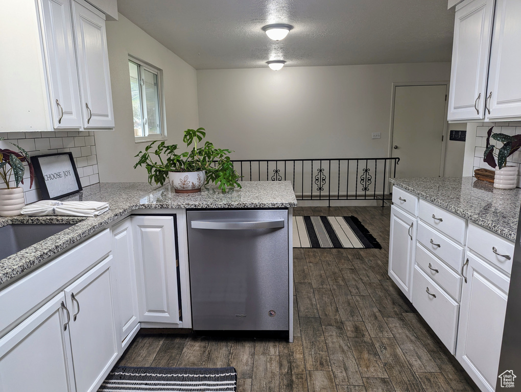 Kitchen with tasteful backsplash, dark hardwood / wood-style floors, dishwasher, and white cabinets