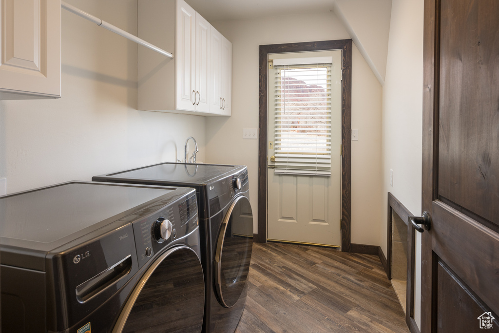 Washroom featuring separate washer and dryer, cabinets, and dark hardwood / wood-style floors