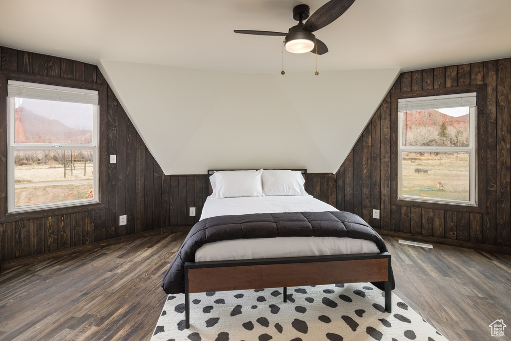 Bedroom featuring multiple windows, dark hardwood / wood-style flooring, and ceiling fan