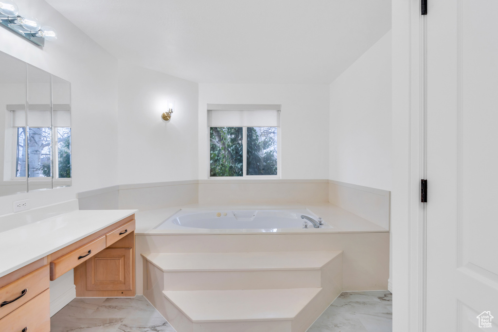 Bathroom featuring vanity, tile flooring, and a tub