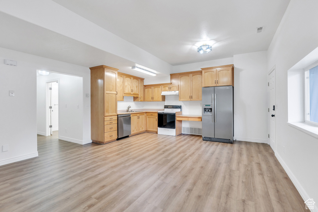 Kitchen featuring appliances with stainless steel finishes, light wood-type flooring, sink, and light brown cabinets