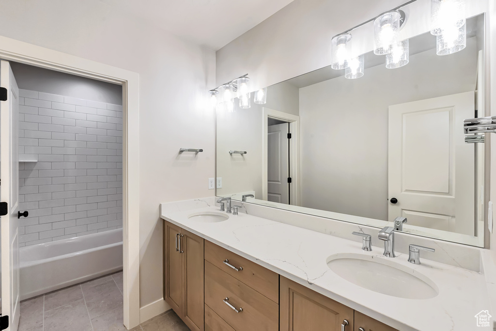 Bathroom with shower / bath combination, double sink vanity, and tile floors
