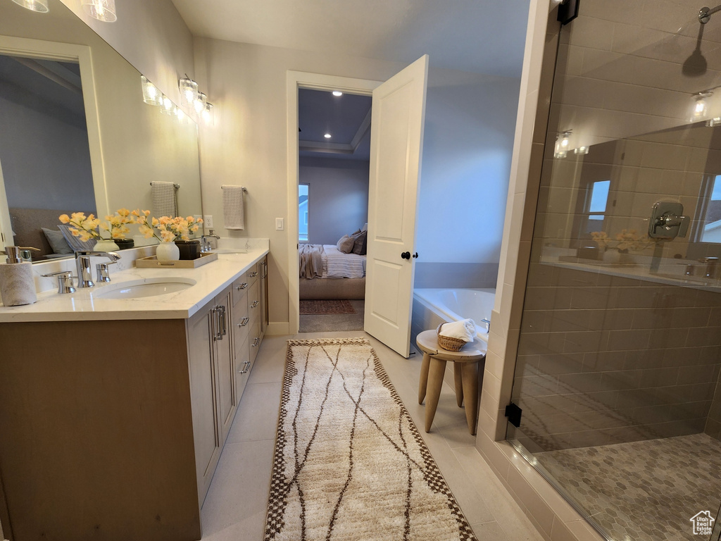 Bathroom featuring plus walk in shower, oversized vanity, and tile floors
