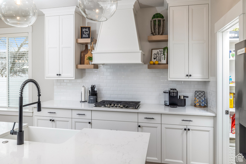 Kitchen featuring white cabinetry, plenty of natural light, and backsplash