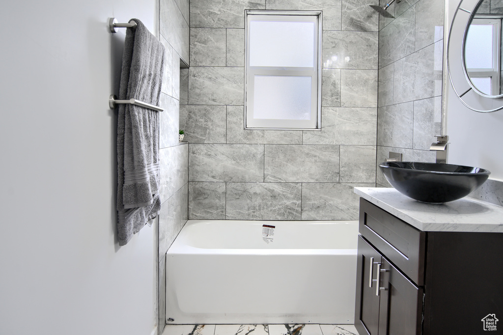 Bathroom with oversized vanity, tile floors, and tiled shower / bath combo
