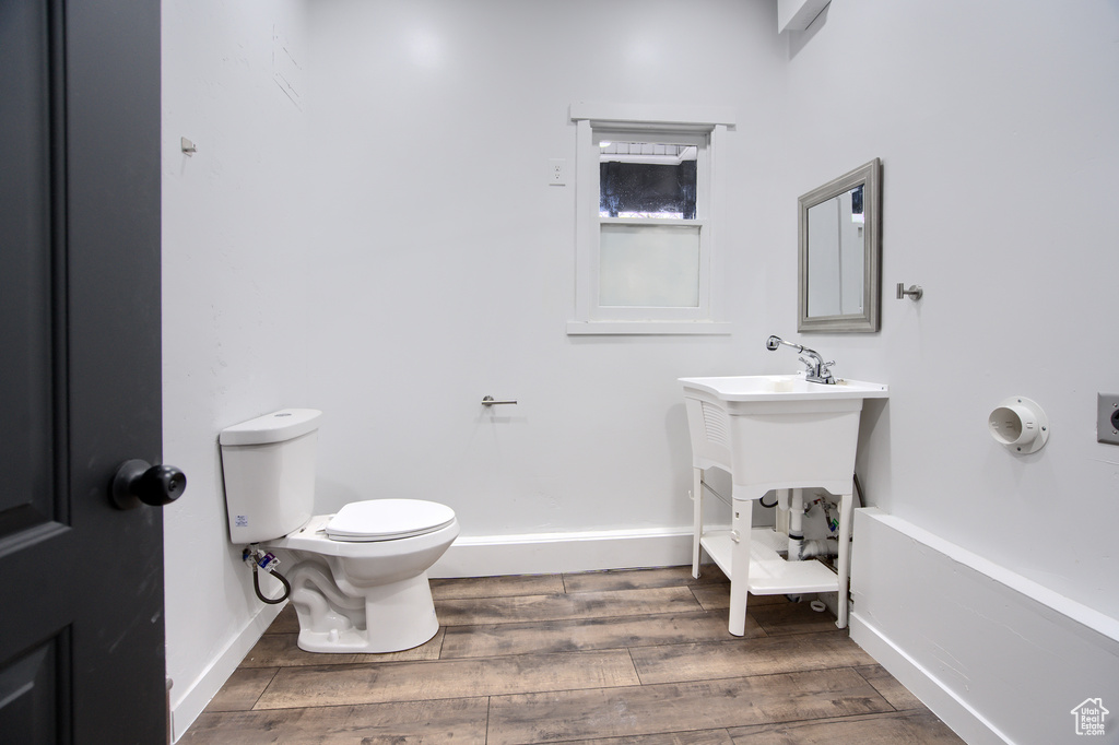 Bathroom with hardwood / wood-style flooring and toilet