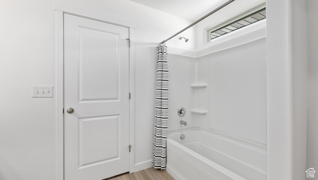 Bathroom featuring shower / bath combo and hardwood / wood-style floors