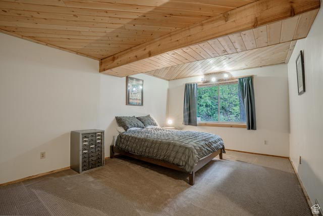 Bedroom featuring carpet floors and wood ceiling