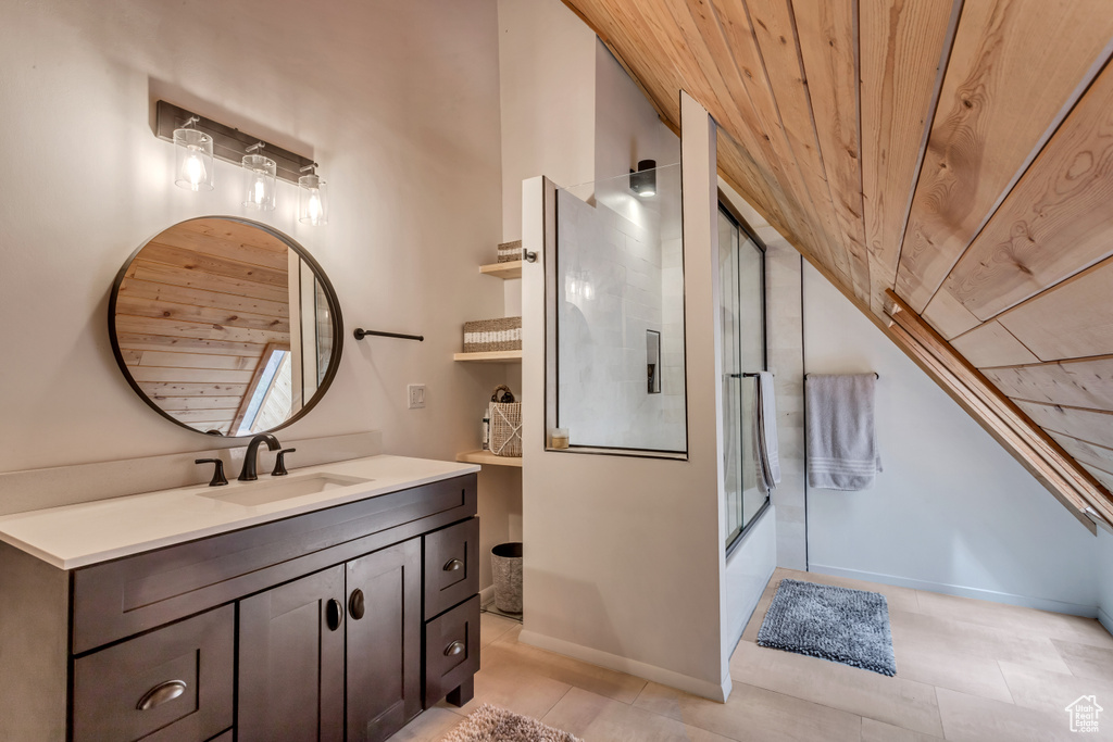 Bathroom with vanity, tile flooring, wooden ceiling, and bath / shower combo with glass door