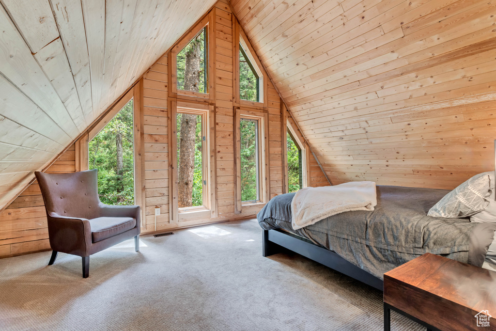 Bedroom featuring light colored carpet, wood walls, lofted ceiling, and wooden ceiling