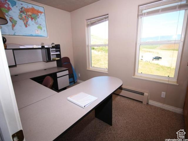Carpeted home office with baseboard heating