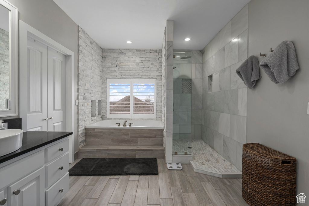 Bathroom featuring separate shower and tub and vanity