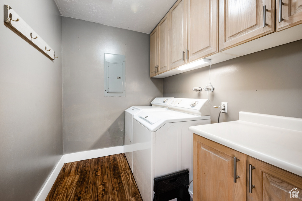 Laundry area with cabinets, dark hardwood / wood-style flooring, and washing machine and dryer